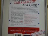 Gablota oszklona, w której wisi biały plakat dotyczący "Tygodnia Zakazanych Książek".