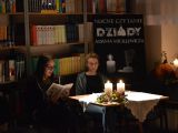 Przy stoliku siedzą dwie uczennice liceum i czytają książkę. Na stoliku stoją dwie zapalone świece.