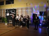 Grupa nastolatków, grających na instrumentach w sali gimnastycznej
