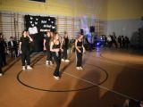 Nastolatki w czarnych strojach tańczą w sali gimnastycznej
