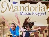 Dwoje uśmiechniętych uczniów. Nad nimi napis Mandoria Miasto Przygód