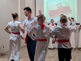 Dwóch uczniów i dwie uczennice  w strojach galowych z czerwonymi akcentami tańczących w parach