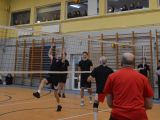 Na sali gimnastycznej dwie drużyny grają mecz siatkówki. Na trybunach uczniowie liceum.