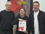 Trzy osoby stojące przed portretem Władysława Łokietka, w środku uczennica z dyplomem, po bokach nauczyciele