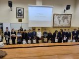 Grupa nastolatków pozujacych do zdjęcia w sali wykładowej