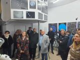 Grupa dorosłych w budynku obserwatorium, Na pierwszym planie teleskop.