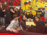 Grupa licealistów w czerwono - żółtym pomieszczeniu. Na ścianach komiksowe rysunki