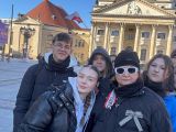 Pięcioro ludzi na tle jasnego budynku katedry
