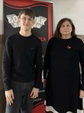 Nastolatek i kobieta na tle roll-upa z napisem Łokietek
