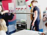 Grupa uczniów w laboratorium fizycznym. Po lewej dziewczynk atrzymająca podłużny przedmiot.