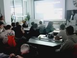 Grupa nastolatków w sali fizycznej podczasprojekcji slajdów na ekranie