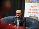 Mężczyzna na kanapie . W tle napis Mamy w sobie niejedno życie