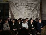 Grupa osób na krzesłach w sali gimnastycznej