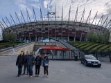 Grupa uczniów przed stadionem piłkarskim. Nad stadionem napis PGE Narodowy