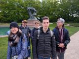 Pięcioro uśmiechniętych ucznió w parku. W tle drzewa i pomnik