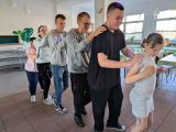 Grupa tańczących, trzymających się za ramiona uczniów