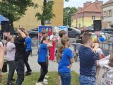 Grupa uczniów stojąca tyłem tańczy w rytm muzyki.