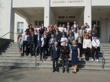 Grupa kilkudziesięciu osób na schodach budynku