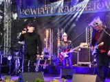 Scena. Na pierwszym planie wokalista i gitarzysta. W tle inni członkowie zespołu.