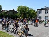 Grupa rowerzystów na tle budynków w małym miasteczku
