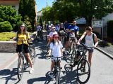 Grupa kilkunastu rowerzystów na ulicy miasta