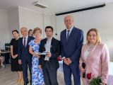 Grupa osób w strojach galowych ustawiona w rzędzie