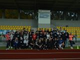 Na stadionie przy barierkacj pod trybunami stoi w kilku rzędach grupa ludzi (65 osób). Są to głównie licealiści, pośród...