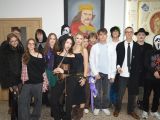 Na szkolnym korytarzu stoi duża grupa licealistów w kostiumach Halloween.