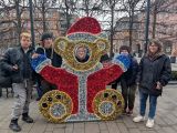 Uczniowie przy fotobudce - podświetlonym lampkami Misiu w stroju Mikołaja. Za nimi drzewa