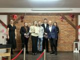 W centrum finalistka konkursu odbiera nagrodę. Towarzyszy jej jury dwie kobiety i mężczyzny, które z uznaniem obserwują...
