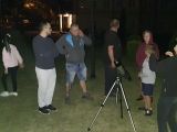 Nocą grupa dziesięciu osób ogląda gwiazdozbiór Wielkiej Niedźwiedzicy. Wszyscy stoją wokół lunety.
