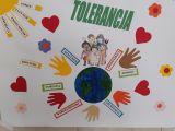 Plakat: kula ziemska otoczona dłońmi ludzi różnych narodowości i hasła dotyczące tolerancji.