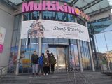 Pięcioro uczniów szkoły podstawowej stoi przed szklanymi drzwiami do kina. Nad drzwiami napis "Multikino".