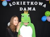Uczennica liceum przytula się do ucznia przebranego w zielony strój żaby.