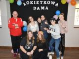 Siedem uczennic liceum stoi w grupie, niektóre mają kapelusze na głowach. Obok nich stoi mężczyzna w czerwonej bluzie.
