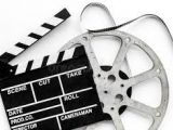 Szarno-białe zdjęcie taśmy filmowej i klapsa.