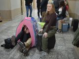 Uczennica liceum siedzi na walizce. Obok stoi różowy dziecięcy napiod, z krótego wystają cztery nogi.