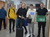 Korytarzem szkolnym idą uczniowie liceu. Jeden trzyma skrzynkę, inny walizkę, inny wiaderko.