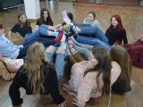 Jedenaścioro uczniów liceum leży na podłodze. Podpierają się na łokciach. Mają podniesione do góry nogi.
