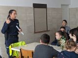 Policjantka w granatowym mundurze z opaską odblaskową w dłoni