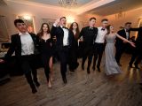 Na środku sali tańczy grupa uczniów liceum - Trzy dziewczyny i sześciu chłopców. Wszyscy trzymają się za ramiona.