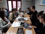W sali przy długim stole siedzi dziesięcioro uczniów liceum. Wykonują doświadczenia chemiczne.
