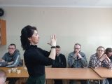 Nauczycielka ze złożonymi dłońmi pokazuje uczniom ćwiczenia Dennisona