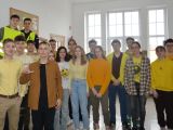 Na korytarzu szkolnym stoi grupa uczniów liceum. Niektórzy ubrani są w żółte koszulki lub bluzy.