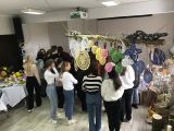 Grupa licealistów stojąca tyłem. Nad nimi wiszące kolorowe serwety i wielkanocne jaja robione na szydełku