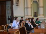 W sali przy dwóch długich brązowych stołach siedzi dziewięcioro uczniów liceum.