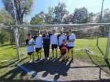Siedmiu uczniów w strojach piłkarskich na boisku piłkarskim  na tle bramki