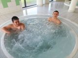 Dwoje uczniów w kąpielówkach siedzących w wodnym jakuzzi