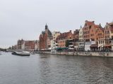 Miasto Gdańsk. Na zdjęciu rzeka Motława. Po obu stronach rzeki budynki.