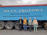 Czworo uczniów stoi przy niebieskiem naczepie samochodu dostawczego